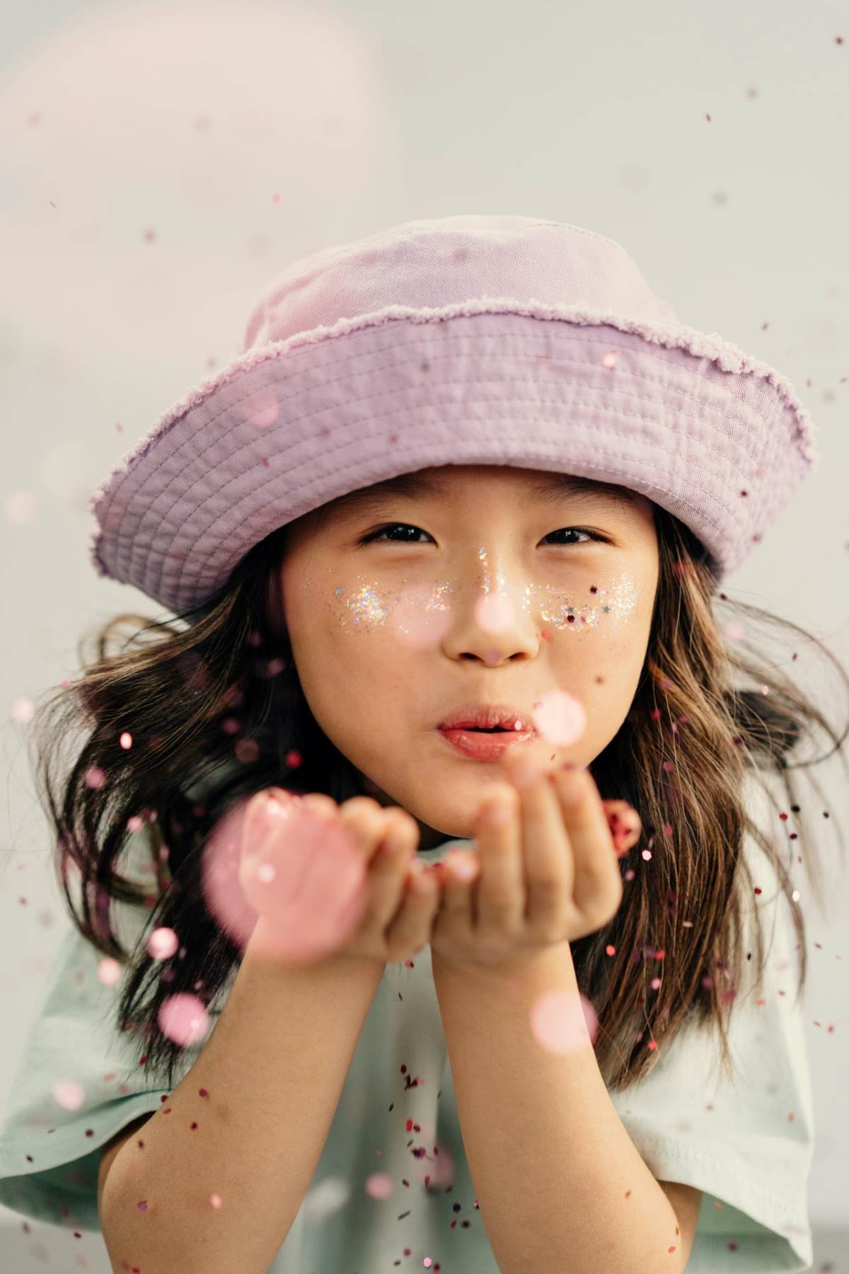 Young girl blowing confetti used in blog post Best Breathing Strategies for Kids