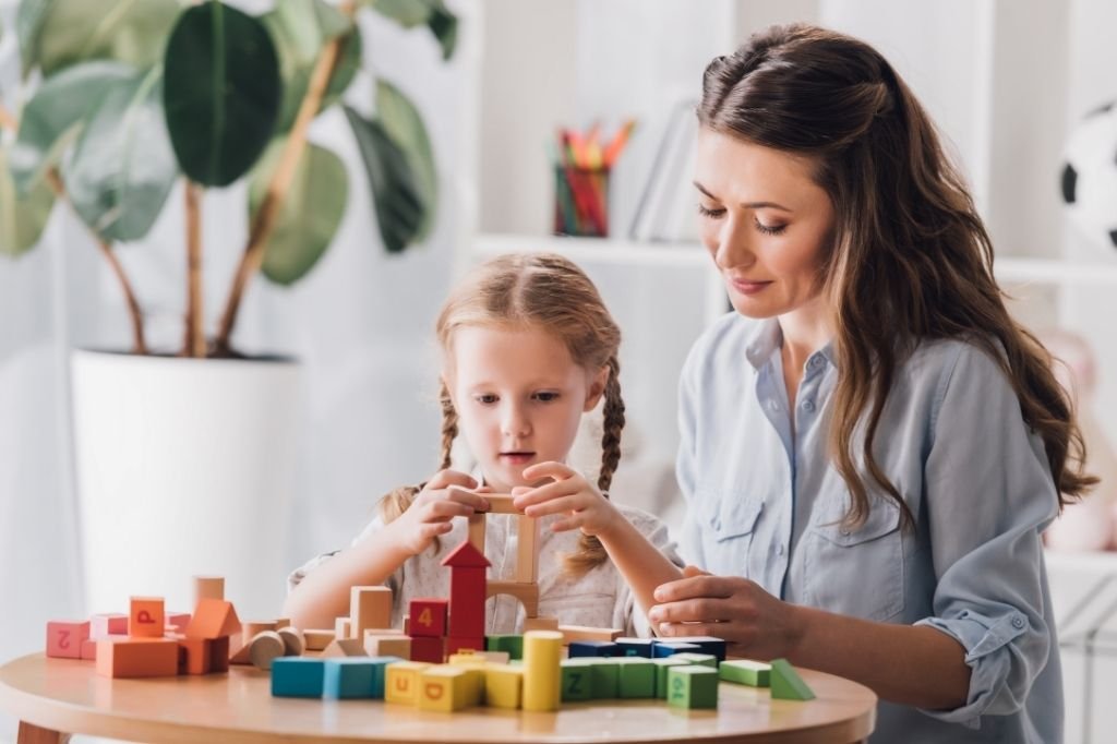 Mum and child playing with building blocks illustrating one of many play therapy techniques parents can use